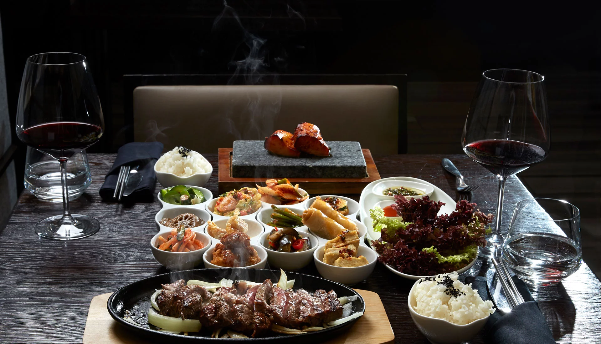 Korean BBQ auf einem Tisch und zwei Gläser Rotwein